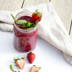Strawberry Basil Smoothie with a napkin and cut strawberries