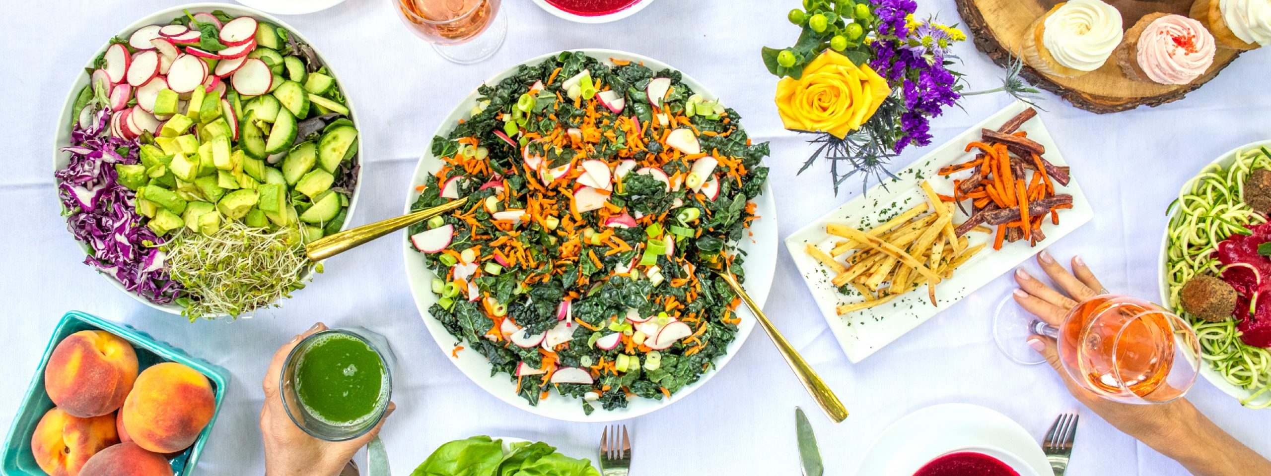 photo of large picnic meal with salads, cupcakes, kombucha and green juice