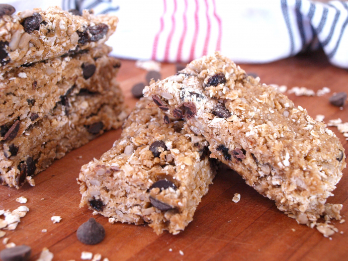 Five oat bars stacked with chocolate chips sprinkled around
