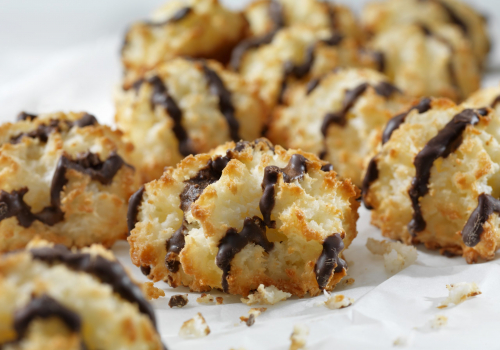 Vanilla Almond Macaroons with Chocolate Drizzle in a row on parchment paper